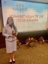 Lucy Lawrence holding her award as nominee for the 2024 Humanitarian of the Year award