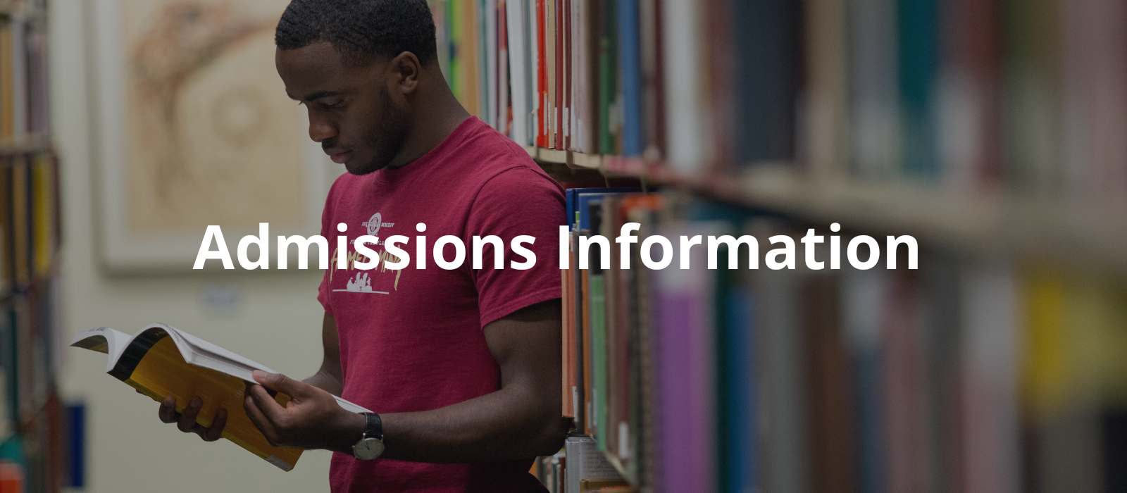 "A person in a maroon t-shirt and khaki shorts stands between bookshelves, reading a yellow book with the words Admissions Information overlaid."