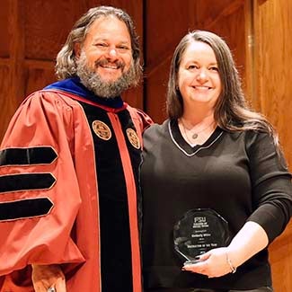 "Dean David Springer in regalia posing with 2026 Instructor of the Year Kimberly White holding her octagonal crystal award."