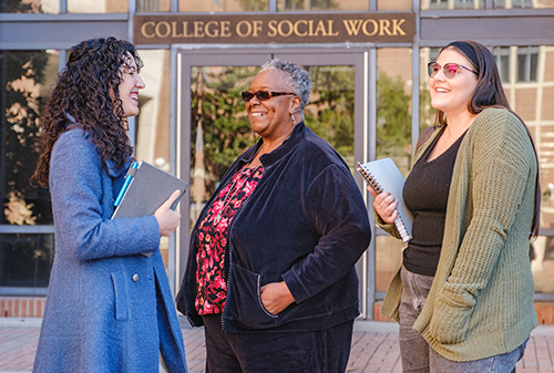 Faculty member Katrina Boone talking with students in the University Center C courtyard