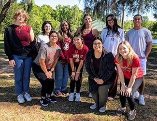 "Erika Cuffy and social work students posing together outside after a service project."