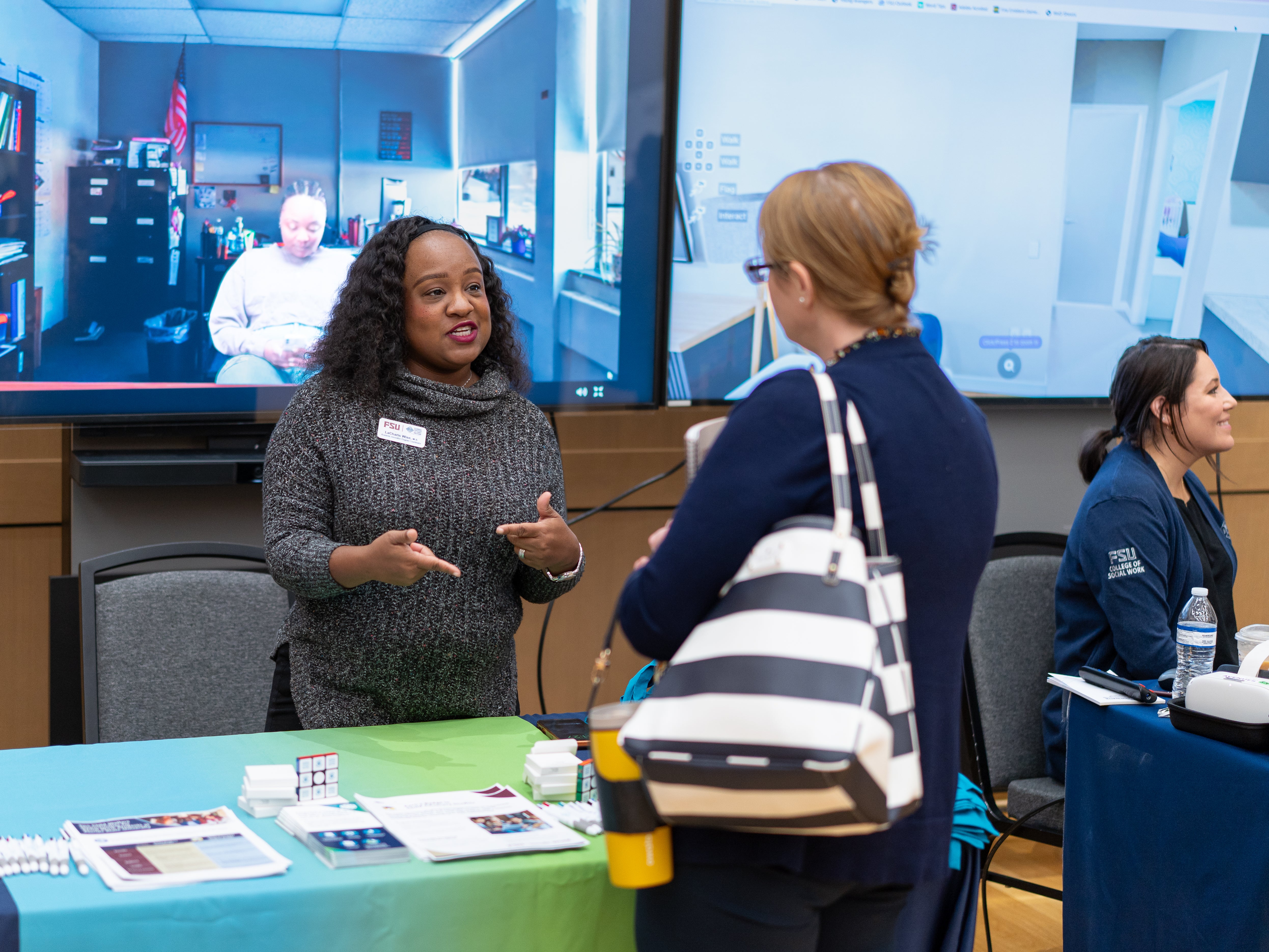 LaCharis Wise sharing information on Florida Institute for Child Welfare trainings with a symposium participant in the Innovation Hall.