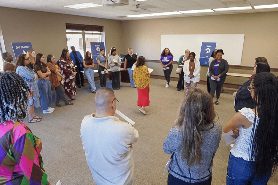 Discovery Days domestic violence simulation participants standing in a circle with presenter Krista Del Gallo standing in the center.
