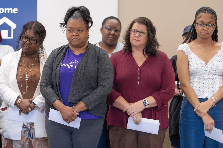 Domestic violence simulation participants standing together with arms folded.