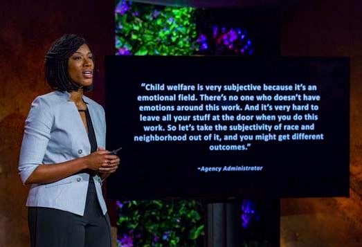 "Dr. Jessica Pryce speaking during her TED Talk next to a screen."