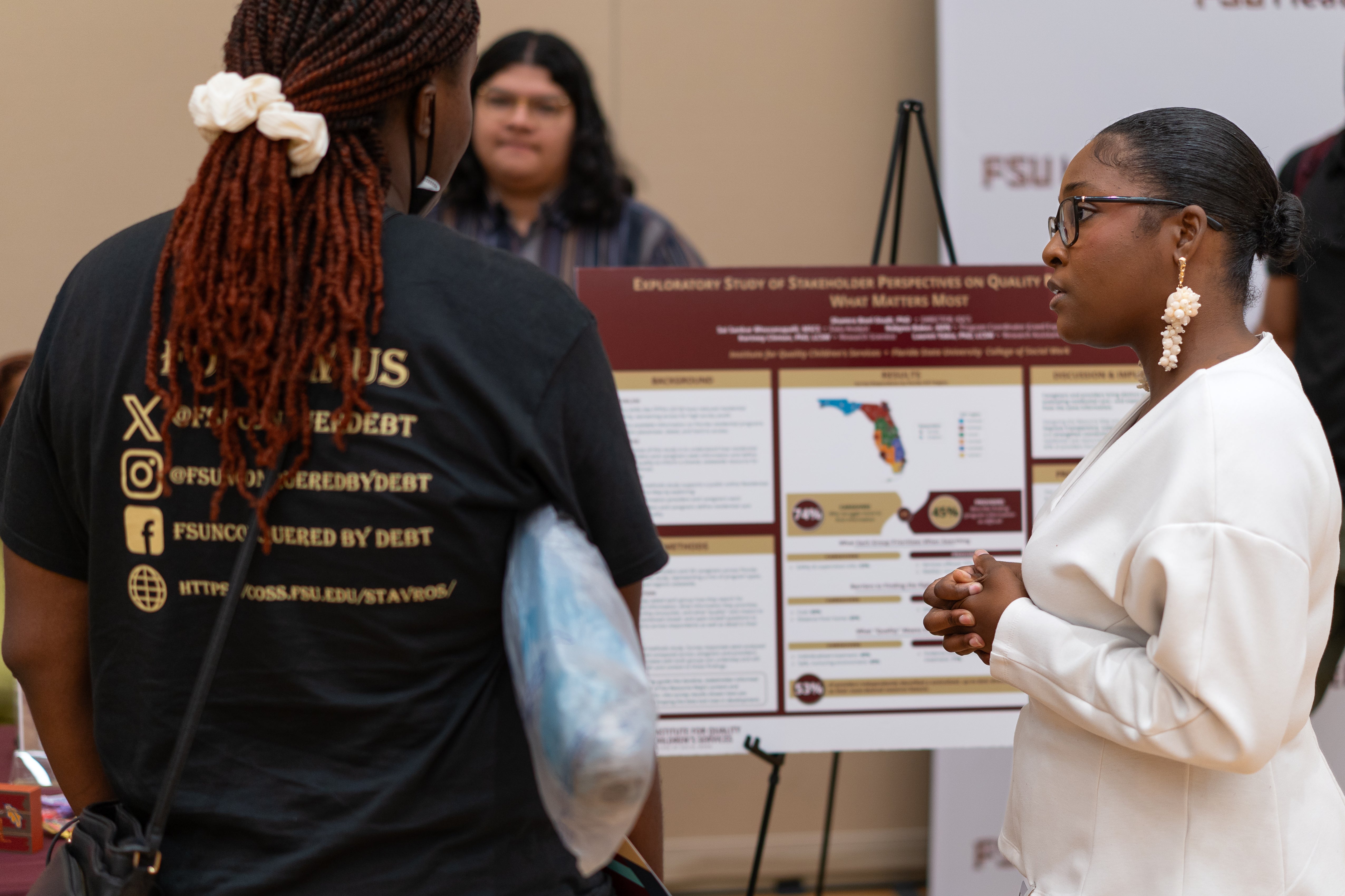 Symposium participants discuss with researchers next to their research posters in the Innovation Hall.