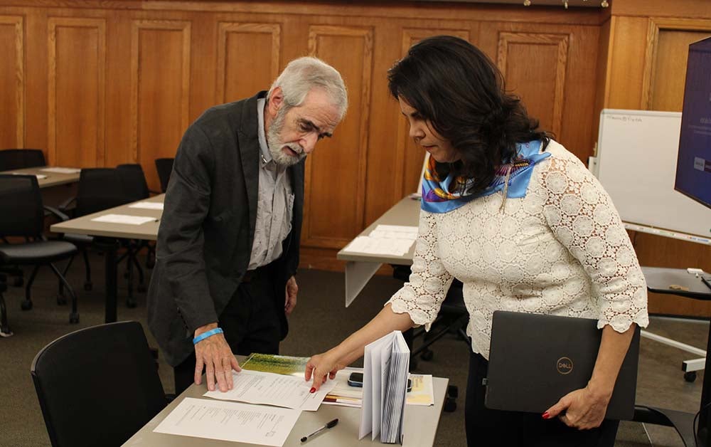 "Dr. Nick Mazza and Dr. Vilma Fuentes reviewing poetry therapy workshop materials."