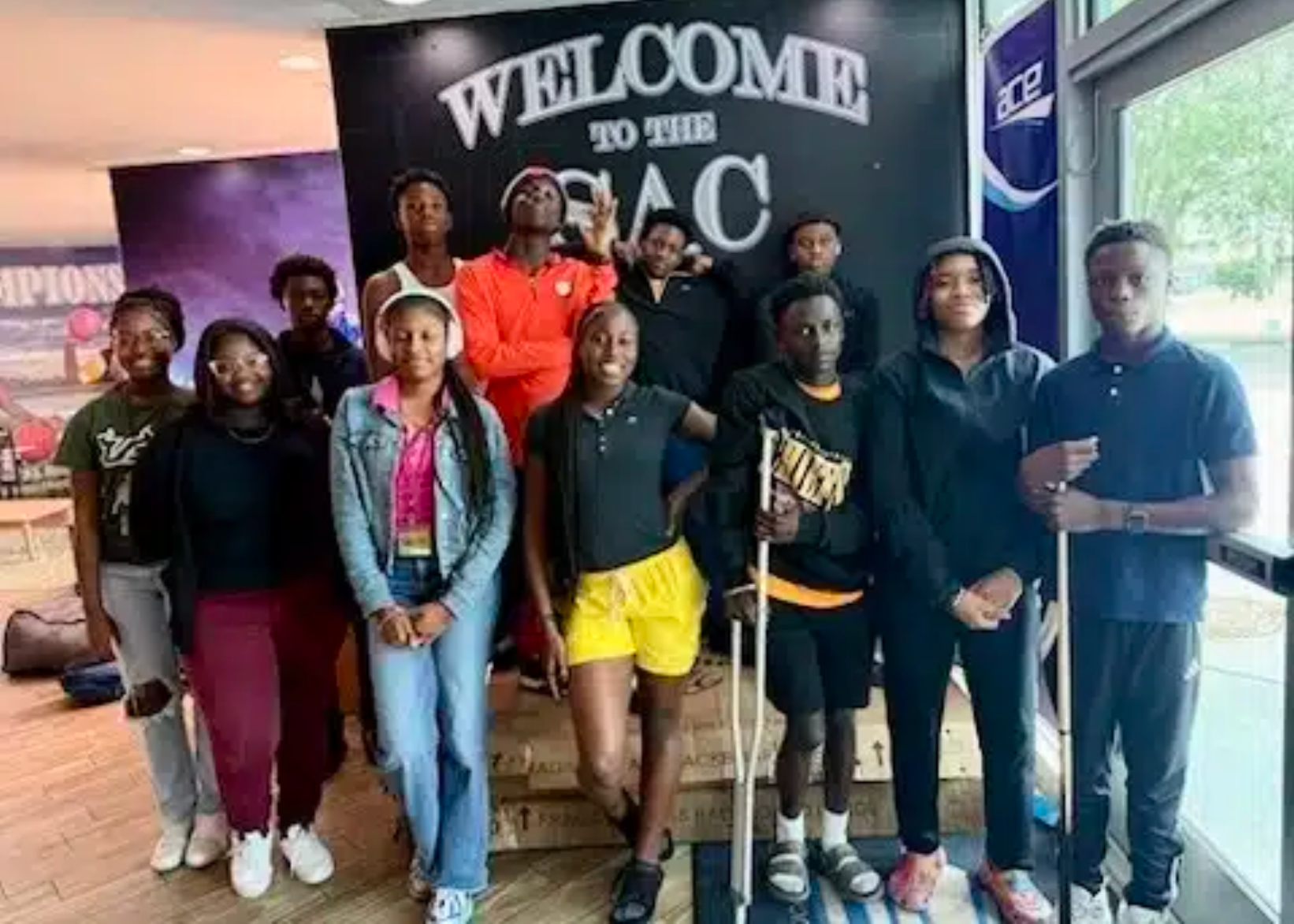 "Students participating in the Student ACES program posing in front of a Welcome to the SAC sign."