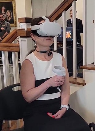 "A woman trying the virtual reality training for child welfare workers at AI Day in the Capital."