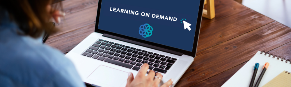 "A person in profile sitting at a desk looking at a laptop screen that says Learning on Demand"