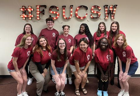 Photo of 2023 College of Social Work Ambassador students in front of the #FSUCSW sign.