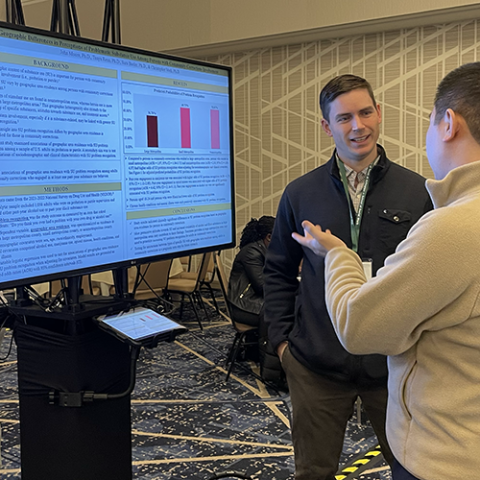 Dr. John Moore presenting a research poster. 