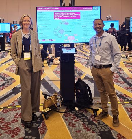 Doctoral Student Shelby Varol and Faculty member Dr. Gashaye Tefera posing with a digital poster at the 2026 Society for Social Work and Research conference.