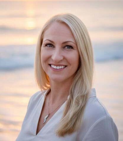 Photo of Sunshine Arnold with beach waves and a sunrise in the background.