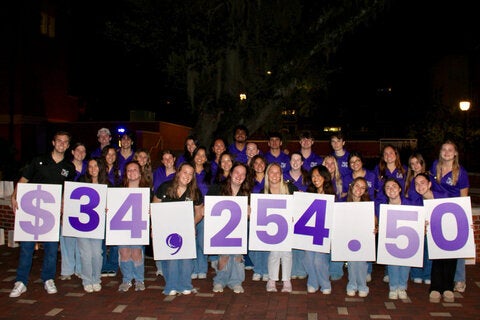 FSU Relay for Life students dressed in purple shirt holding up cardboard numbers showing $34,254.50 raised in 2026.