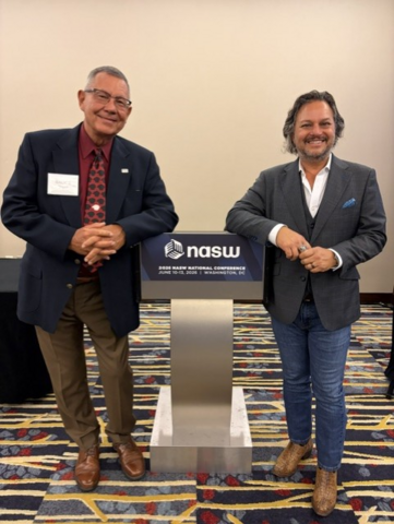 Bruce Thyer and David Springer posing at the National Association of Social Workers 2026 Annual Conference leaning on a podium
