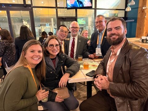 Dean Kirk Foster and Dr. Bruce Thyer centered posing with attendees at the Big Kahuna Atlanta reception.