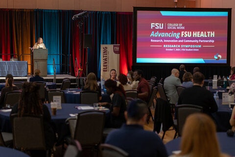 Dr. Lisa Magruder speaking at a podium at the opening of the FSU Health Research Symposium.