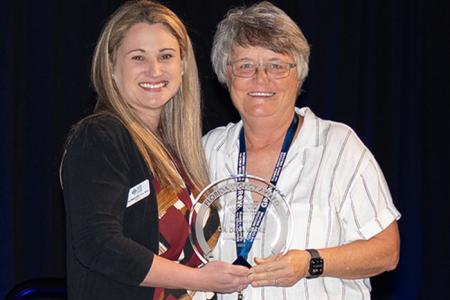 Dr. Lisa Magrude and Dr. Dina Wilke posing with the Florida Institute for Child Welfare inaugural Legacy Award presented to Dr. Wilke. 