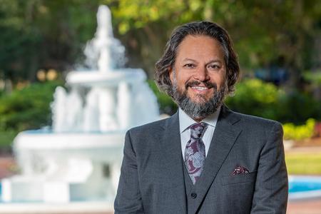 Dean David Springer in a three piece suit standing in front of the Westcott Fountain.