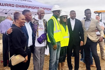 Charlie and Tanja Ward posing in hard hats and sunglasses at the groundbreaking of the Charlie Ward Champions Ranch site with other collaborators standing in a line.