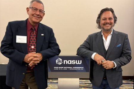 Bruce Thyer and David Springer posing at the National Association of Social Workers 2026 Annual Conference leaning on a podium
