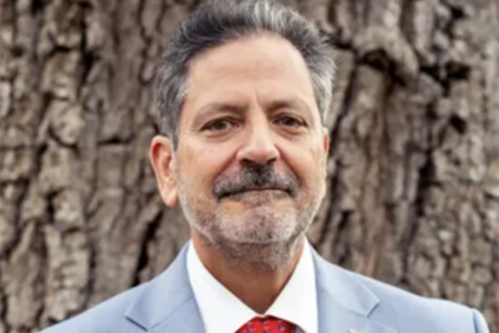 Headshot of Dominic Calabro wearing a light blue suit and red tie.
