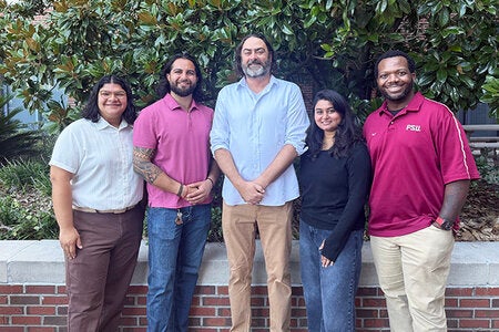 Photo of 2026 Doctoral Cohort Pedro Serrano Mejia, Russ Sharif and Sherin Thomas posing with Doctoral Program team Dr. Stephen Tripodi and Kam Green.