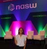 Jalynn French posing in front of a colorful lit display at the National Association of Social Workers National Conference.