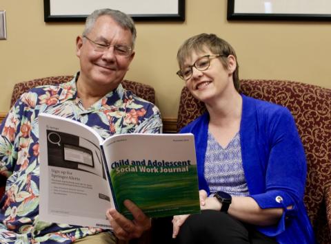 Bruce Thyer and Lisa Schelbe reading the Child and Adolescent Social Work Journal they co-edit.