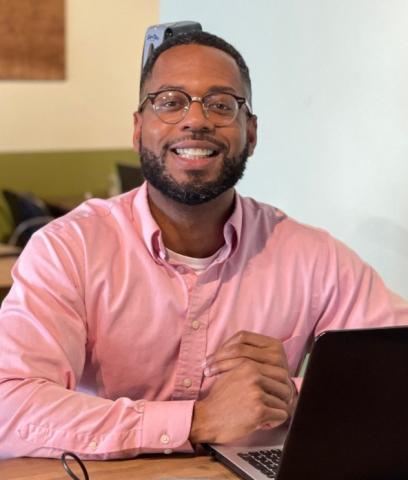 Tyron Slack at a computer in a coffee shop,