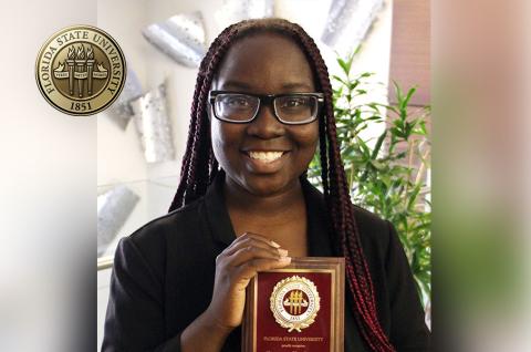 Conqualla Scott holding up her 2023 FSU Humanitarian of the Year Award plaque.