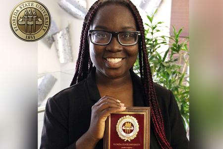 Student Conqualla Scott holding up her 2023 FSU Humanitarian of the Year plaque.