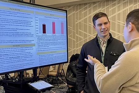 Dr. John Moore presenting a research poster. 